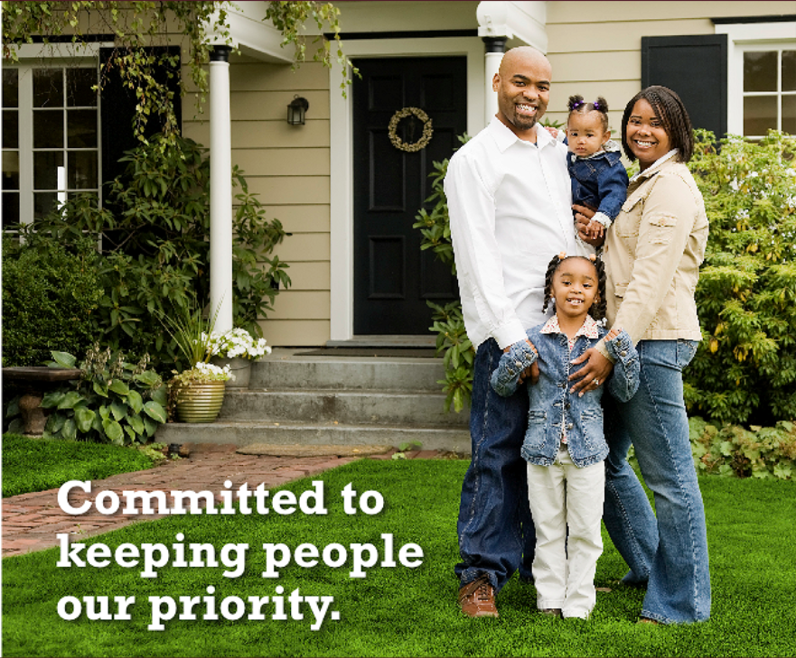 family posing in front of home